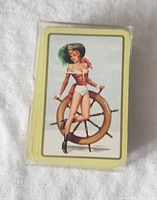 Photo of the deck showing card back design with 1950s pinup girl leaning on ship steering wheel.
