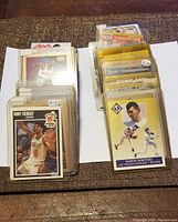 Top view of multiple sports cards in toploaders with some cards identifiable such as Rony Seikaly and Ramon Martinez.