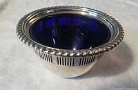 Birks sterling silver dish with cobalt blue glass insert showing front and bead rim detail.