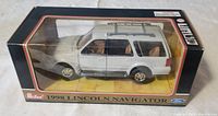 Front view of sealed die cast 1998 Lincoln Navigator model in black display box with clear window showing silver vehicle.