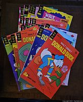 Photo showing a fan spread of 25 Gold Key Disney comics from the 1970s with visible colorful covers featuring Donald Duck and related characters.