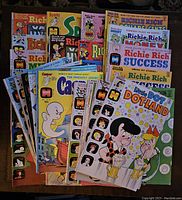 Full view of the lot of over 25 Harvey comic books from the 1970s including Casper, Richie Rich, Little Dot, and Spooky titles stacked and spread out.