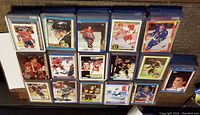 Photo showing multiple hockey cards in toploaders, featuring players from various teams like Montreal Canadiens, Boston Bruins, Toronto Maple Leafs, and Detroit Red Wings from vintage sets.