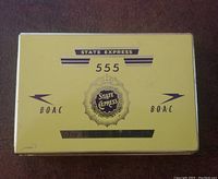 Yellow metal rectangular tin with State Express 555 and BOAC branding seen from lid top down view showing minor wear and small lower left corner scratch