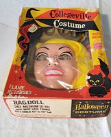 Front view of the vintage boxed mask with mop hair fringe visible through plastic window on box.