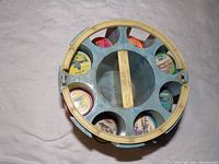 Top-down view of blue plastic carousel holding stacks of circular airplane coins with colorful printed airplane illustrations on top