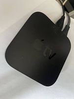 Top view of black Apple TV device showing Apple logo and 'tv' marking.