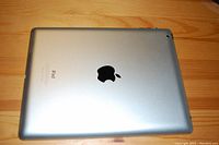 Back side of the iPad showing silver aluminum case, Apple logo, and iPad branding.