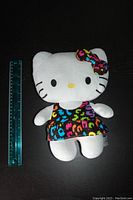 Front view of Hello Kitty plush with ruler for scale.