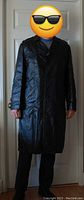 Front view of vintage long black leather men's trench coat worn by model 6' tall showing length and fit.