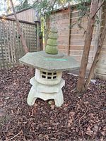 Full assembled lantern outdoors on bark mulch against wooden fence