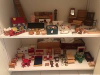 Overall view of two white shelves holding an assortment of miniature furniture pieces and accessories