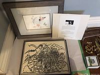 Framed hummingbird watercolor print by Sue Coleman leaning against wall alongside other items