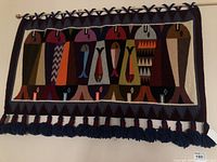 Full front view of tapestry hung on dowel rod showing overall pattern and fringe.