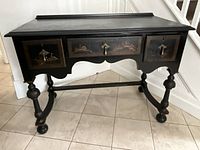 Frontal view of entire desk showing three drawers, turned legs and stretcher base