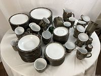Overhead view showing full set of Denby Marrakesh stoneware pieces on white background.
