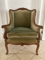 Front view of chair showing full wingback form, removable cushion, upholstery and frame