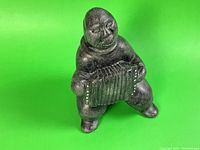Full view of Inuit soapstone sculpture depicting an accordion player.