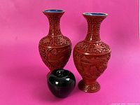 Pair of red cinnabar lacquer vases with blue enamel interiors and brass rims, plus green apple for size reference