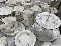 Tea cups, saucers and two-tiered pastry stand grouped together