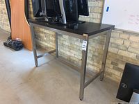 Table from the side view showing metal legs and damaged corner on tabletop