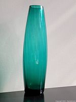 Front view of turquoise glass vase showing smooth surface and rounded rim.