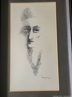 Front view of framed ink drawing showing stylized portrait in black ink and visible signature dated 1963.