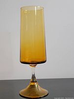 Full view of the 14-inch tall amber glass vase with clear stem, showing its height and form.