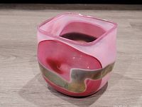 Front angle showing pink glass with green swirl design on square bowl