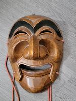 Front view of the hand carved wooden Korean mask showing detailed carving and black painted eyebrows.