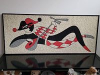 Full front view of framed mosaic showing the entire reclining jester figure