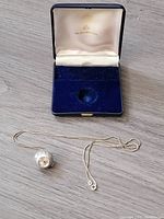 Original blue velvet and cream satin Bucherer box open with the watch and chain laid out below.