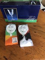 Two pairs of packaged LeBelle glass slipper socks, one orange and one white