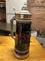 Side view of one beer stein showing detailed hand-painted scene with horse and flowers