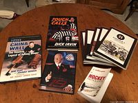 Photo of six hockey-related books and CDs displayed on a wooden table.