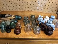 Full view of the variety of hydro insulators arranged on a wooden surface, showing different styles, materials and colors.