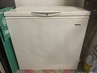Front view of Kenmore chest freezer showing minor dents on the top surface and overall white finish.
