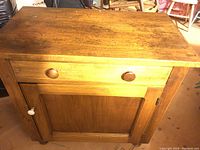 Front view of the wooden wash stand cupboard showing drawer and door closed