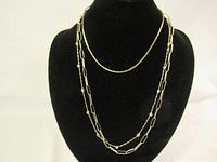 Front view of the lot on a black display bust showing all three silver necklaces.