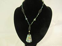 Full view of one necklace with abalone shell mosaic pendant displayed on black bust.