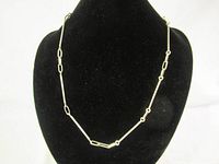 Full view of silver necklace displayed on black bust background showing link pattern and overall design.