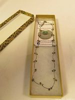 Full view of the necklace in a decorative box with authenticity card