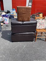 Two large brown storage stools stacked with a small brown fabric stool on top; part of the miscellaneous furniture lot