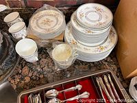 Floral patterned china dinnerware including cups, bowls, and plates stacked together