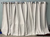 4 blackout curtains hanging showing white decorative side.