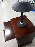 Top view of wooden dresser showing writing top drawer and black lamp on top