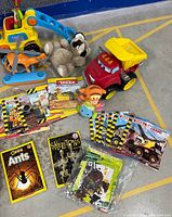 Toys including plastic helicopter, orange skateboard, plush raccoon, red Tonka dump truck, and 12 Tonka-themed children's books along with kids educational books and a puzzle