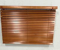 Photo showing a medium brown faux wood horizontal blind measuring approximately 72 by 45 inches.