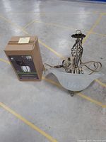 Outdoor lantern light in sealed box next to the decorative dining light fixture on the floor