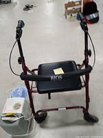 Full view of the foldable Rios walker featuring a padded seat and handlebars with brakes, showing the front part with wheels.